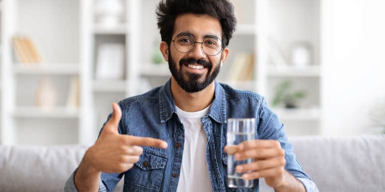 smiling man holding glass of water