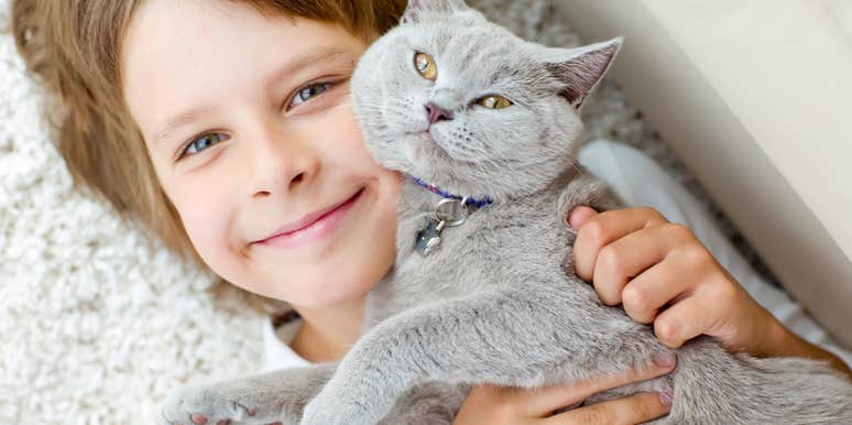 little boy hugging affectionate cat