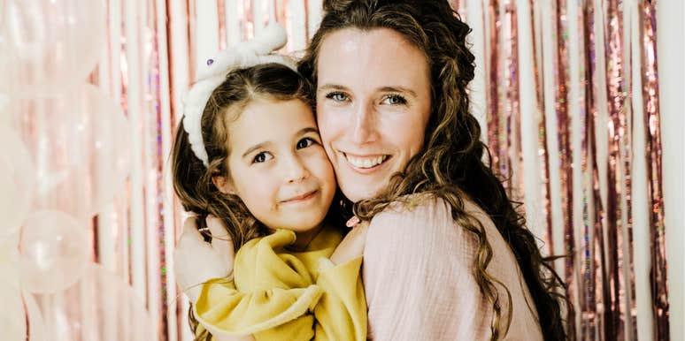 Mother holding her daughter closely.