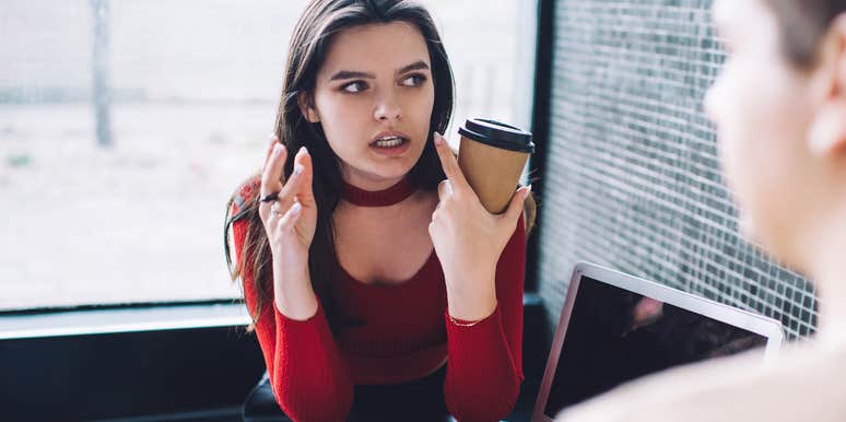 Woman in red top being irrational spouse in cafe