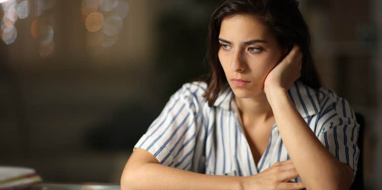 A woman looking contemplative, representing the signs of someone who was chronically invalidated as a child and how it affects them in adulthood