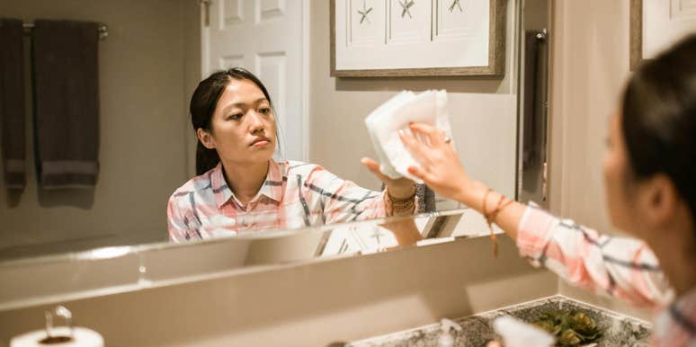 Woman cleaning mirror