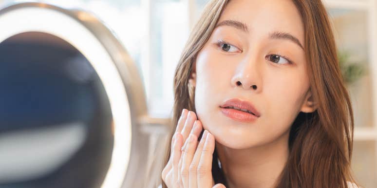 woman scrutinizing herself in the mirror