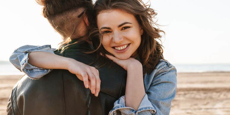 Woman smiling over shoulder of man she pulled back from slipping away