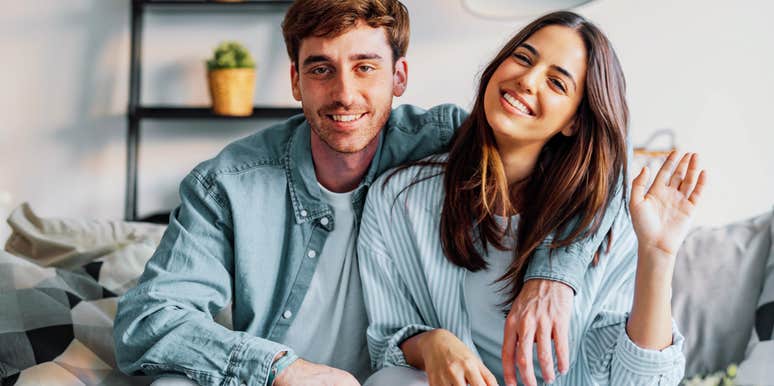 Man possessively putting his arm around his partner. 