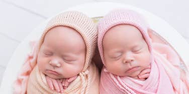 two newborn baby girls swaddled next to each other