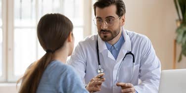 male doctor in white medical uniform talk discuss results or symptoms with female patient