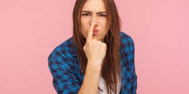 woman pointing at her nose implying someone is lying