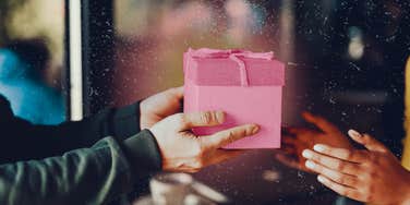 Generous person hands off gift to the person he is in a relationship with.