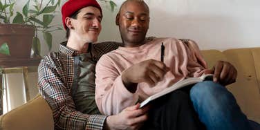 Queer situationship hugging on the couch. 