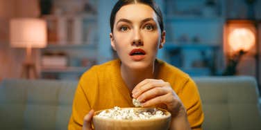 woman with popcorn watching engaging movie