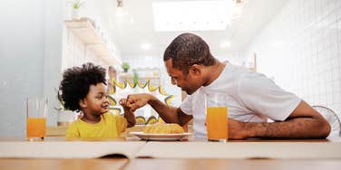 Father and son fist bumping over breakfast, Childs admiration of his father
