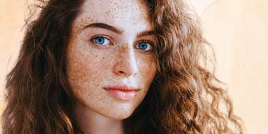 Woman with freckles trying on a new life