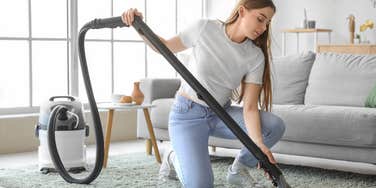 AirBnb host vacuuming the carpet of her home. 