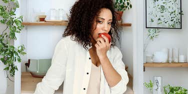 Confident healthy woman eating an apple