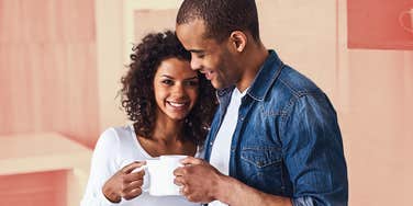 Couple in kitchen keeping each other close