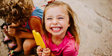 Young child happily eating a popsicle