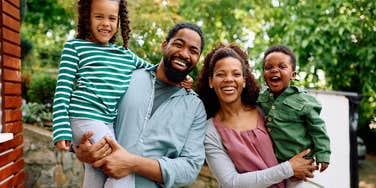 happy family smiling outside their home