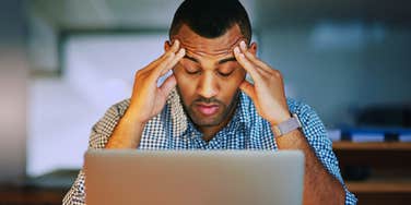 Man in front of computer is experiencing toxic stress.