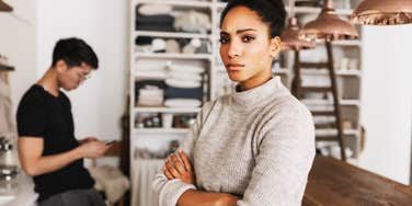 Woman feeling disrespected by partner, arms crossed.