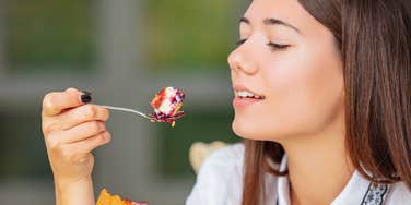 woman eating a slice of cheesecake