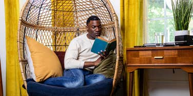 man reading in cozy nook