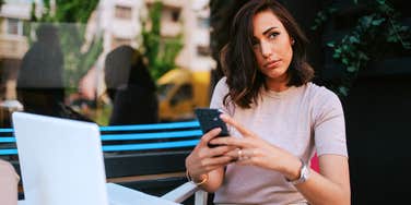 Angry woman deciding if she should text her partner