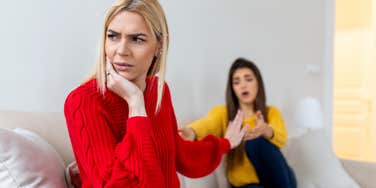 one woman trying to apologize while another angry woman looks away