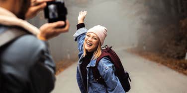 Man taking cute photos of his girlfriend while on a hike.