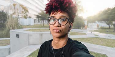 Person looking confident and smiling at the camera outside. 