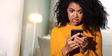 Woman looking at phone because ex is trying to get her back.