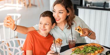 mom and son taking picture together eating at restaurant 