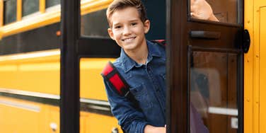 boy leaning out of school bus