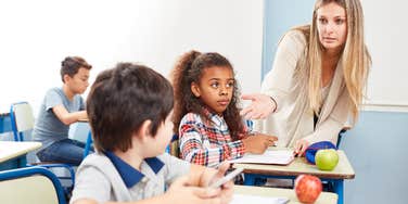 Teacher taking student's phone away in class