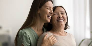 Mother and her daughter hugging and smiling.