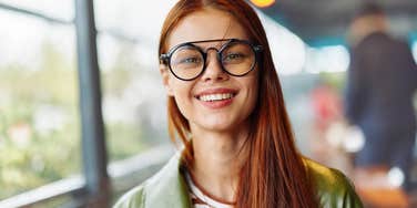 red headed woman with glasses smiling