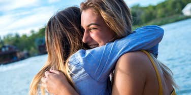 Woman hugging friend knows the secret to being a likable person.