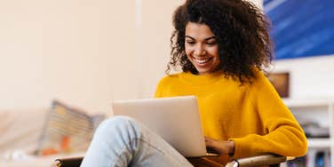 woman sitting in her home working on laptop