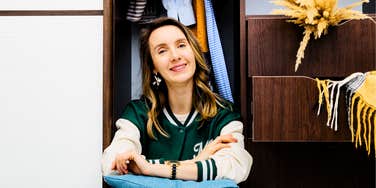 Woman sitting in closet not shopping to retire ten years early.