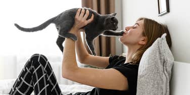 Cat putting their paw on their owner