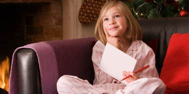 Girl writing Christmas wish list