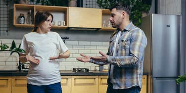 pregnant woman and man arguing in kitchen 