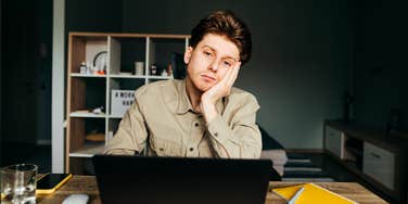 Person feeling miserable in their head at desk. 