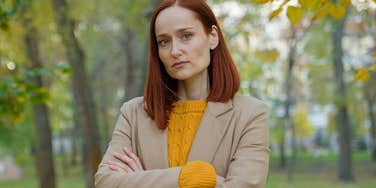 offended woman standing outside with her arms crossed