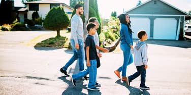 Family walking in front of homes in suburbs.