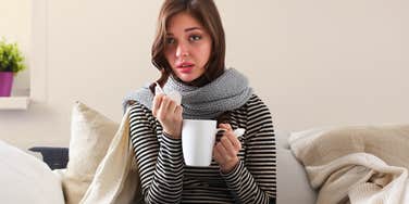 Wife sick on the couch wishing husband wouldn't disappear