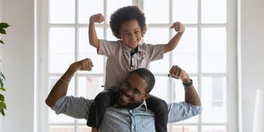 Dad and toddler showing off muscles