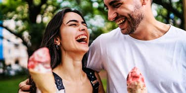 Truly happy and thriving couple, smiling while eating ice cream.