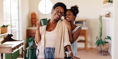 single mom with her daughter drinking coffee in the kitchen