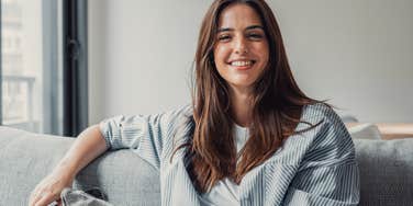 Woman smiling and sitting on her couch